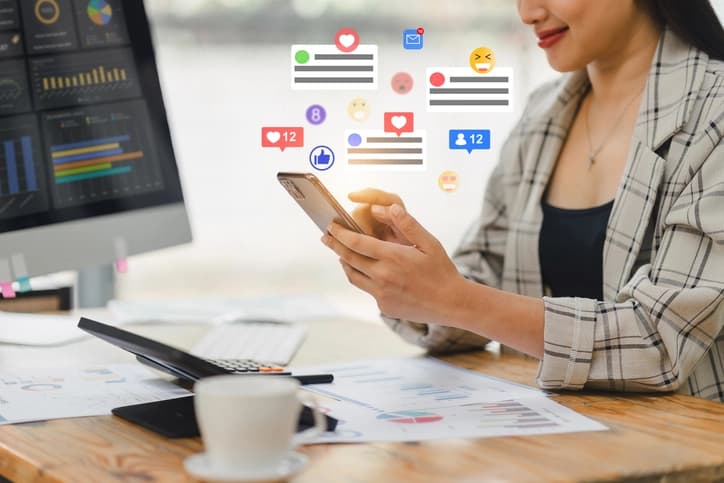 Professional using smartphone with social media engagement metrics and analytics